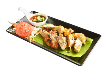 grilled chicken with chili sauce on banana leaf isolated on white
