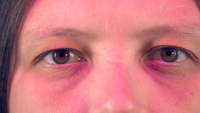 Young woman with tired eyes from long work at computer shows various exercises for eyes, approved by doctor. Gymnastics against strabismus. Remedial exercises. Ophthalmological allowance