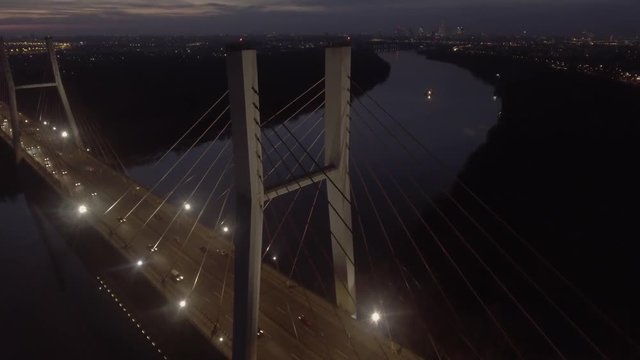 Aerial view of the illuminated night Siekierkowski Bridge crossing the Vistula River in Warsaw Poland.