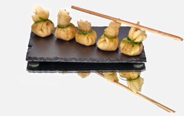 Delicious shrimp dumpling lined up on a black slate