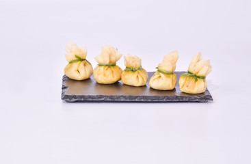 Delicious shrimp dumpling lined up on a black slate
