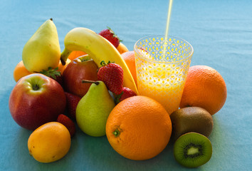 Colorful Fresh Fruits And Juice on blue sky background.