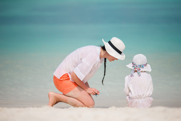 Little girl and young mother during beach vacation