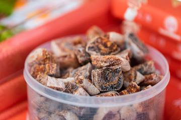 Traditional dried persimmon fruit for sampling or buying in Takayama morning market in container in Japan macro closeup