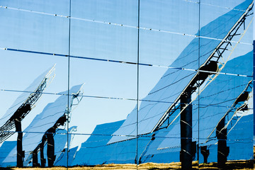 Reflection of modern solar panels on glass wall during sunny day in photovoltaic power station in countryside