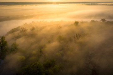 Obraz na płótnie Canvas Sunrise over foggy riverbank. Fog on river aerial view. Misty river in sunlight from above