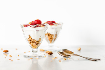 Fresh Raspberries on Top of Granola and Yogurt Parfait On Light Background, Space For Text