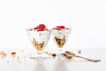 Fresh Raspberries on Top of Granola and Yogurt Parfait On Light Background, Space For Text