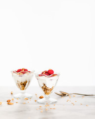 Fresh Raspberries on Top of Granola and Yogurt Parfait On Light Background, Space For Text