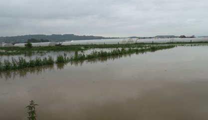 Aerial view of rural farm flooding featuring farm house, on dry flooded fields