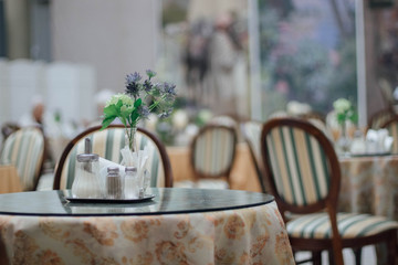 Empty restaurant in light colors with flowers on the table