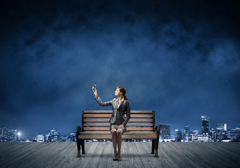 Young woman in business suit holding smartphone