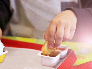 Obraz na płótnie Canvas Children's hand dips a biscuit in ketchup