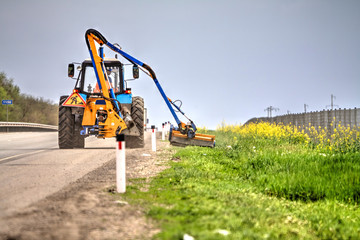 Tractor with a mechanical mower mowing grass