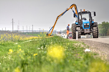 Tractor with a mechanical mower mowing grass