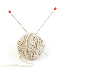 Ball of yarn with knitting needles isolated on white background.