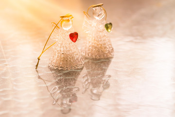 Two glass angels with hearts on the table