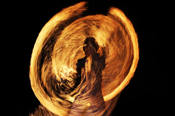 silhouette of a man against a background of sparks and fire during a fiery show