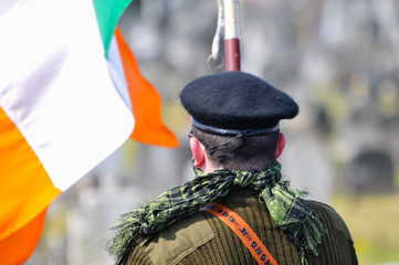 A man in paramilitary uniform, with an Irish tricolour as he commemorates the Easter Rising of 1916 - obrazy, fototapety, plakaty