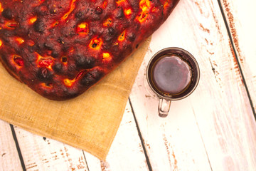 Italian bread with cheese, tomatoes and herbs. Focaccia on the table.