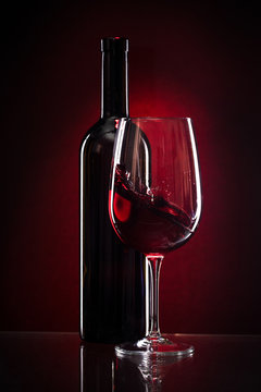 wine glass and bottle of red wine on a dark red background Stock Photo |  Adobe Stock