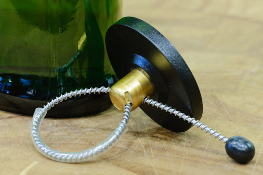 A security tag removed from a bottle lies on a table