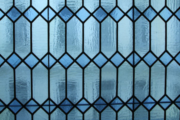 A detail of an old stained glass in the Art Nouveau style in the window in an old house. 