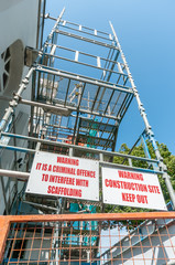 Scaffolding and warning signs at a building site.