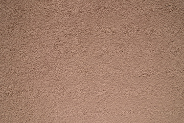 Peach plastered wall in sunlight. Modern building materials for
