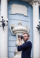 Tourist talking a photo with a DSLR camera in European city outdoors.