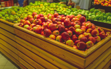 Ripe apple in wooden box Fresh striped apples in wooden box with straw