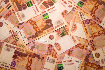 Banknotes of Russian currency face value of 5,000 rubles scattered on the table are a sign of riches and prosperity.