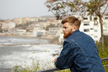 People and lifestyle concept. Attractive thoughtful young European male with long ginger beard...