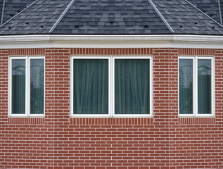 classical vintage design window on weathered red brick blocks fence wall background.