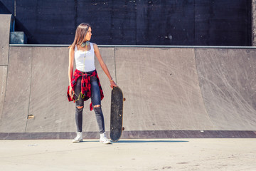 Urban girl skateboarder in skateboard park.
