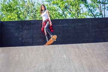 Girl having fun riding skateboards at skate park.