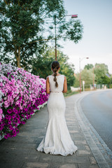 Beautiful bride shooting next to purple flowers and smelling them