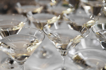 Alcohol cocktails, martini, vodka and others on decorated catering bouquet table on open air event or wedding.
