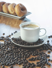 Coffee cup and roasted coffee beans. on wooden background.