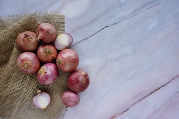 Fresh red Onion on a sack cloth againts a marble background