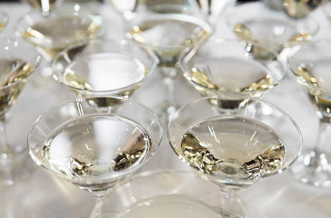 Alcohol cocktails, martini, vodka and others on decorated catering bouquet table on open air event or wedding.