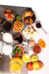 Huge healthy breakfast on table with coffee, orange juice, fruits, waffles and croissants. Good morning concept.