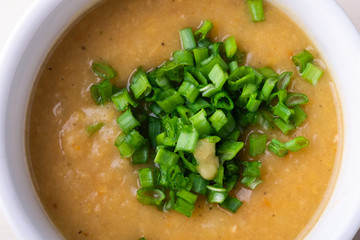 Soup puree with onion in the white plate top view