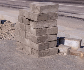 Pavement stones for footpath stacked near the road. construction, industrial.