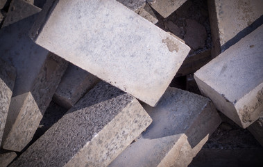 Pile of dirty gray curb bricks. background, vignetted texture.