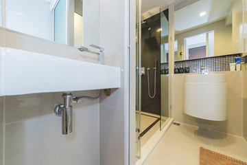 Condo bathroom design with single vanity cabinet and grey tiles on the walls.