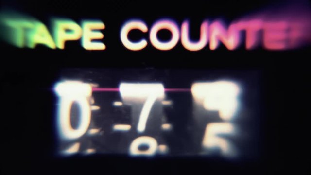 A retro vintage tape counter, macro shot with psychedelic hippie color distortion, going from a hundred to zero.