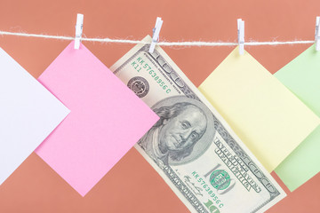 Colorful paper cards and money hanging rope isolated on brown background. Place for your text.