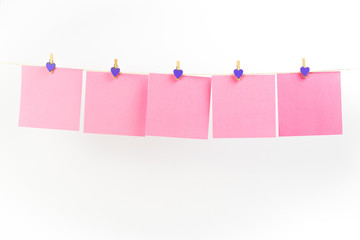 Pink stickers on clothesline with clothespins isolated on white background. Place for your text.