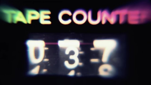 Macro close-up shot: a retro vintage tape counter, psychedelic trippy color distortion, going from zero to a hundred.